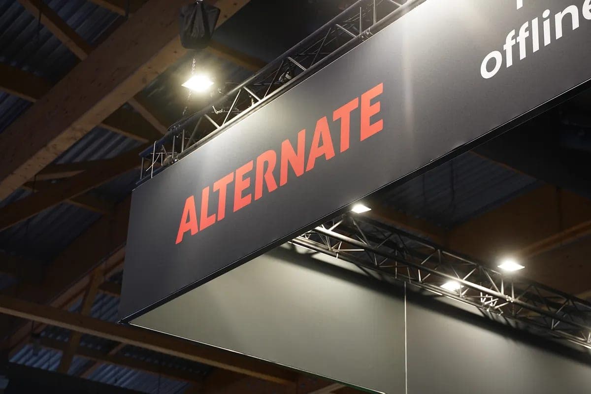 De ALTERNATE-stand op een beurs, met het logo op een groot scherm